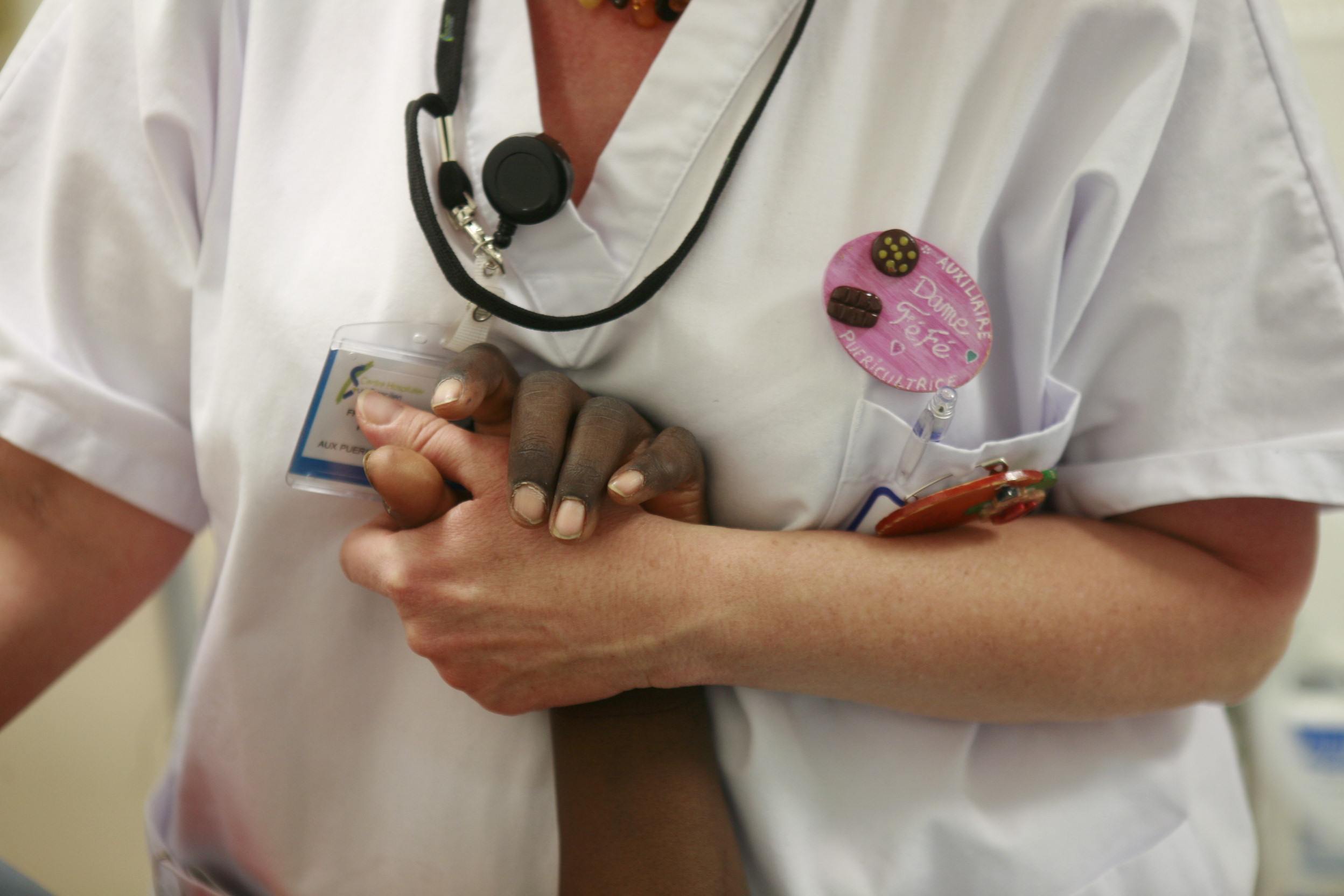 Une infirmière de pédiatrie tient la main d'un enfant au CHSF